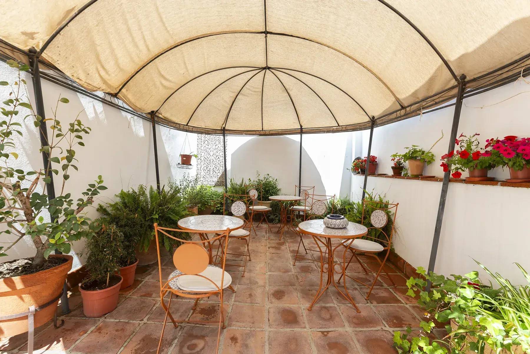 Patio interior de la hospedería, con mesas y toldo abovedado